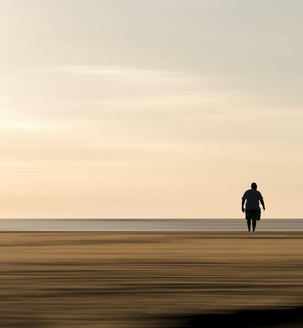 Person meditating peacefully outdoors with soft natural background.